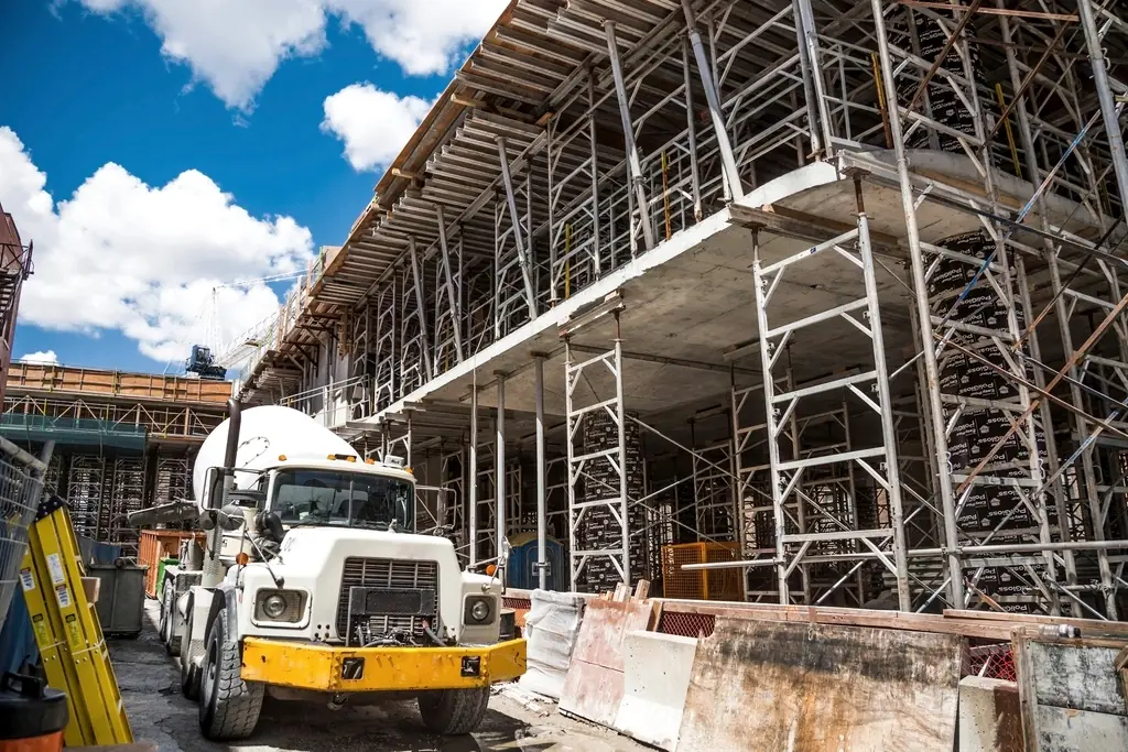 Concrete mixer truck beside a multi-storey structure under construction